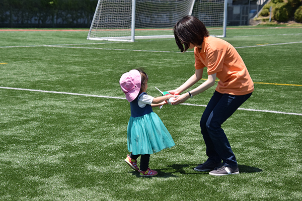 飛ばしたロケットを子どもたちの元にお届け。グラウンドを何往復も走り回るのは大変ですが、ニッコリ笑顔で対応。