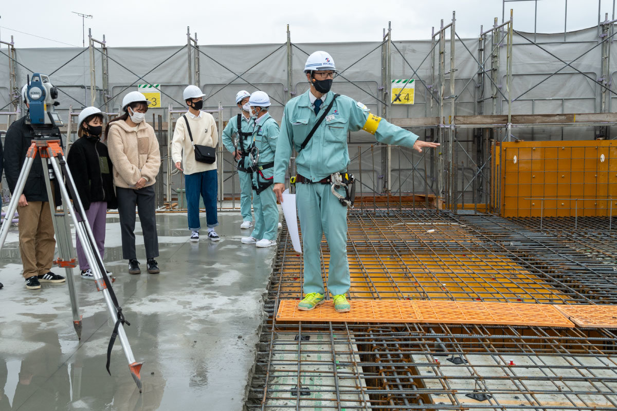 左半分はコンクリ打設済、右半分は鉄筋むき出しの床。鉄筋の組み方について説明を受けます。