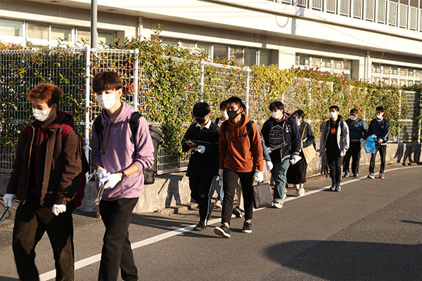 大学周辺の清掃に向かう学生