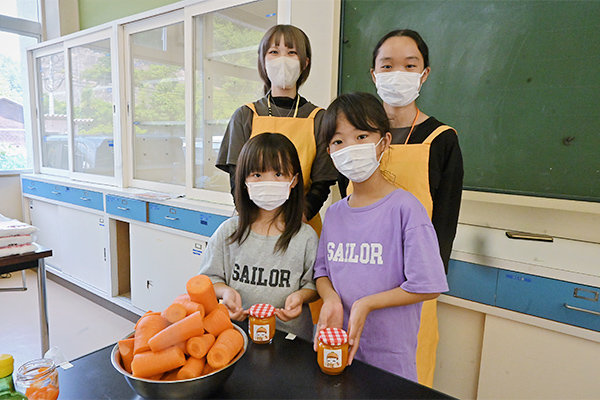 瓶詰めしたジャムにキャロミのオリジナルラベルを貼って完成。大内さん（広島県立安芸府中高等学校出身／広島県）と神崎さん（広島県立安芸府中高等学校出身／広島県）と一緒に記念撮影