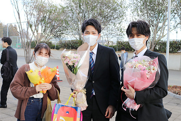 後輩から花束を受け取る学生も