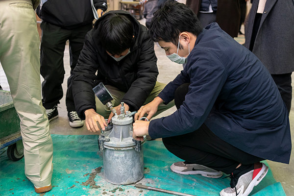 こちらは空気量測定。バケツのような容器にコンクリートを詰めた後、蓋をして空気を圧縮します。