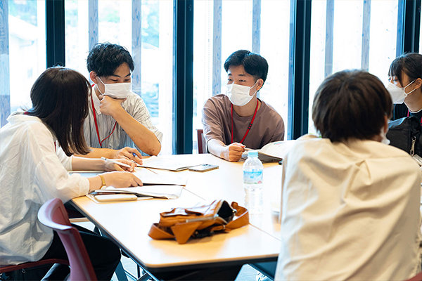 「なぜ宮島に宿泊しないんだろう？」と相談する学生たち