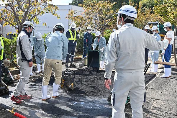 施工時のアスファルト混合物の温度は150度ほどにも。学生たちは注意しながら作業にあたる