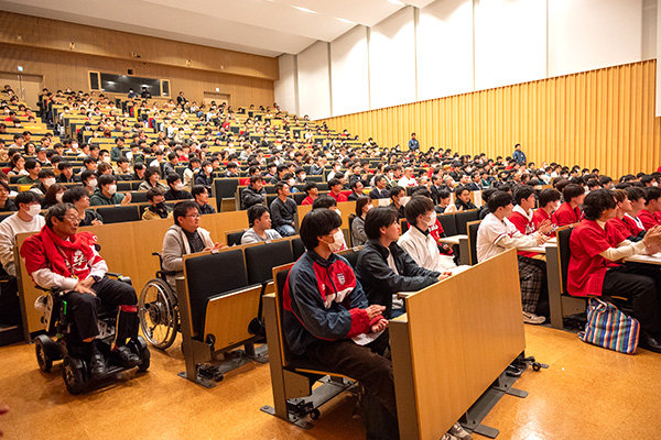 赤いユニフォームを着た学生でいっぱいのデネブホール