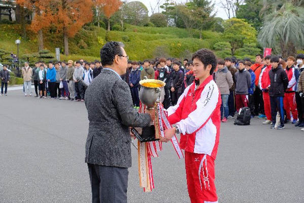 部活動の部で昨年優勝した陸上競技部の「チームマニーズ」が、優勝カップを返還