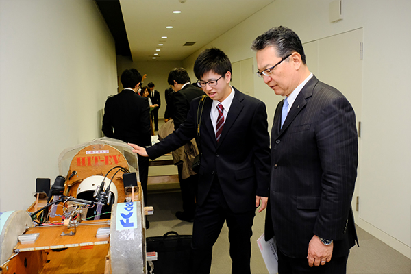 鶴学長にマシンを紹介するTeam HIT-EVの大西宏樹さん（知能機械工学科3年）