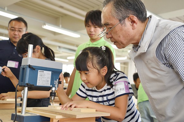 先生の指導のもと、穴をあける位置を定める慎重なまなざし