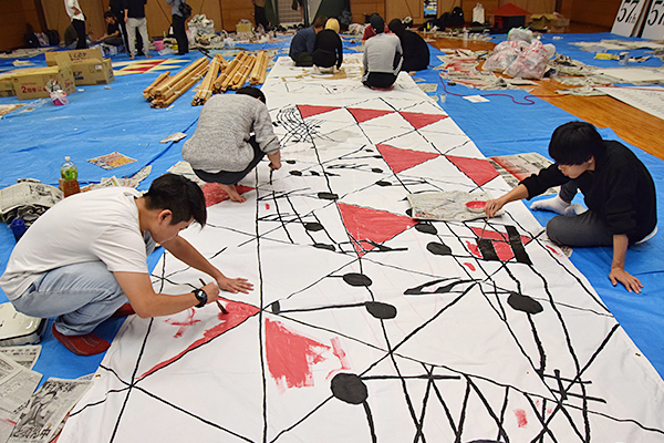 横断幕に色付け中。すでに賑やかな雰囲気を感じさせます。