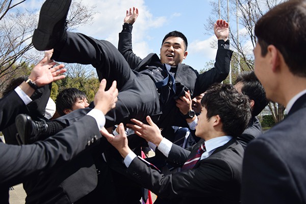 胴上げで派手に卒業生を祝福するラグビー部。