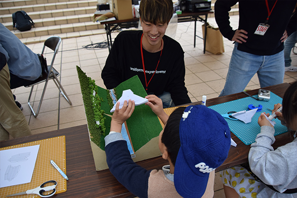 子どもたちと砂防ダムのペーパークラフト製作。作り方と一緒に学生が防災についてレクチャーしていました。