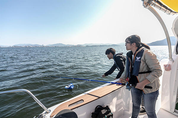 クローバーブイを網に乗せ、静かに海面へと浮かべます。