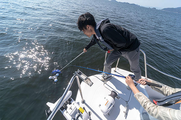 観測が終了すると、釣り竿のリールを巻いてブイを近づけ、最後は網ですくいます。内部の電子機器を壊さないよう、慎重に。